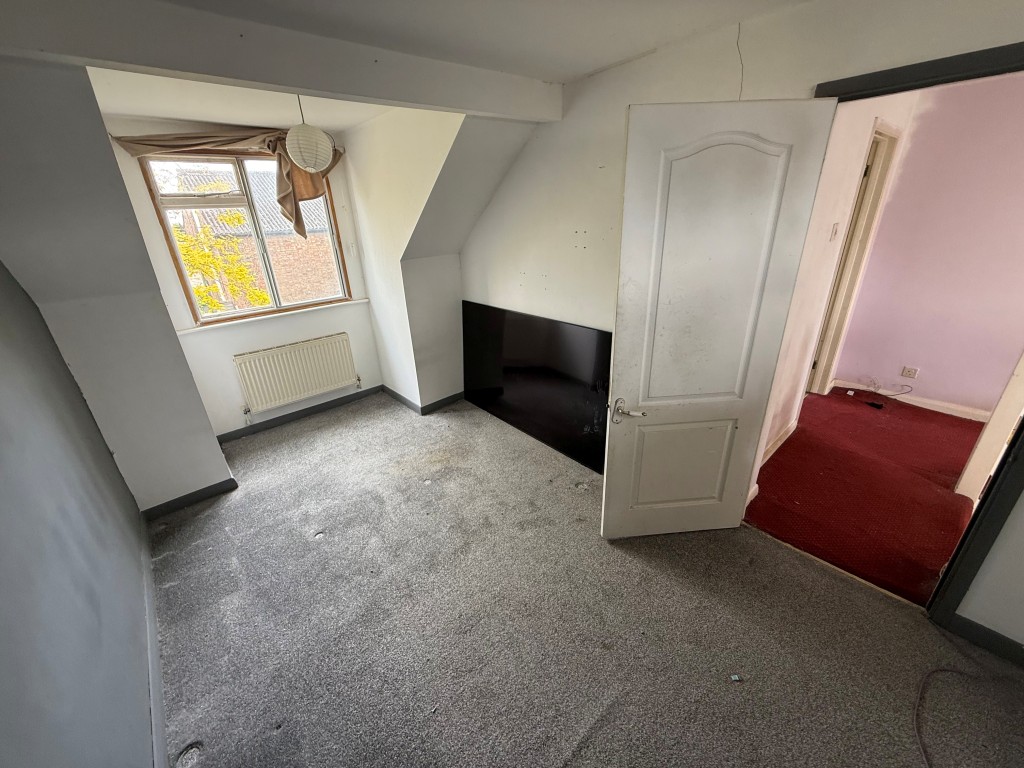Lot: 136 - FOUR-BEDROOM DETACHED HOUSE FOR REPAIR AND MODERNISATION - Bedroom three with slanted roof and showing window